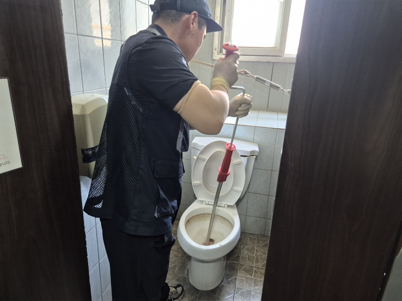 전동 와이어를 변기에 넣고 작업하는 사진