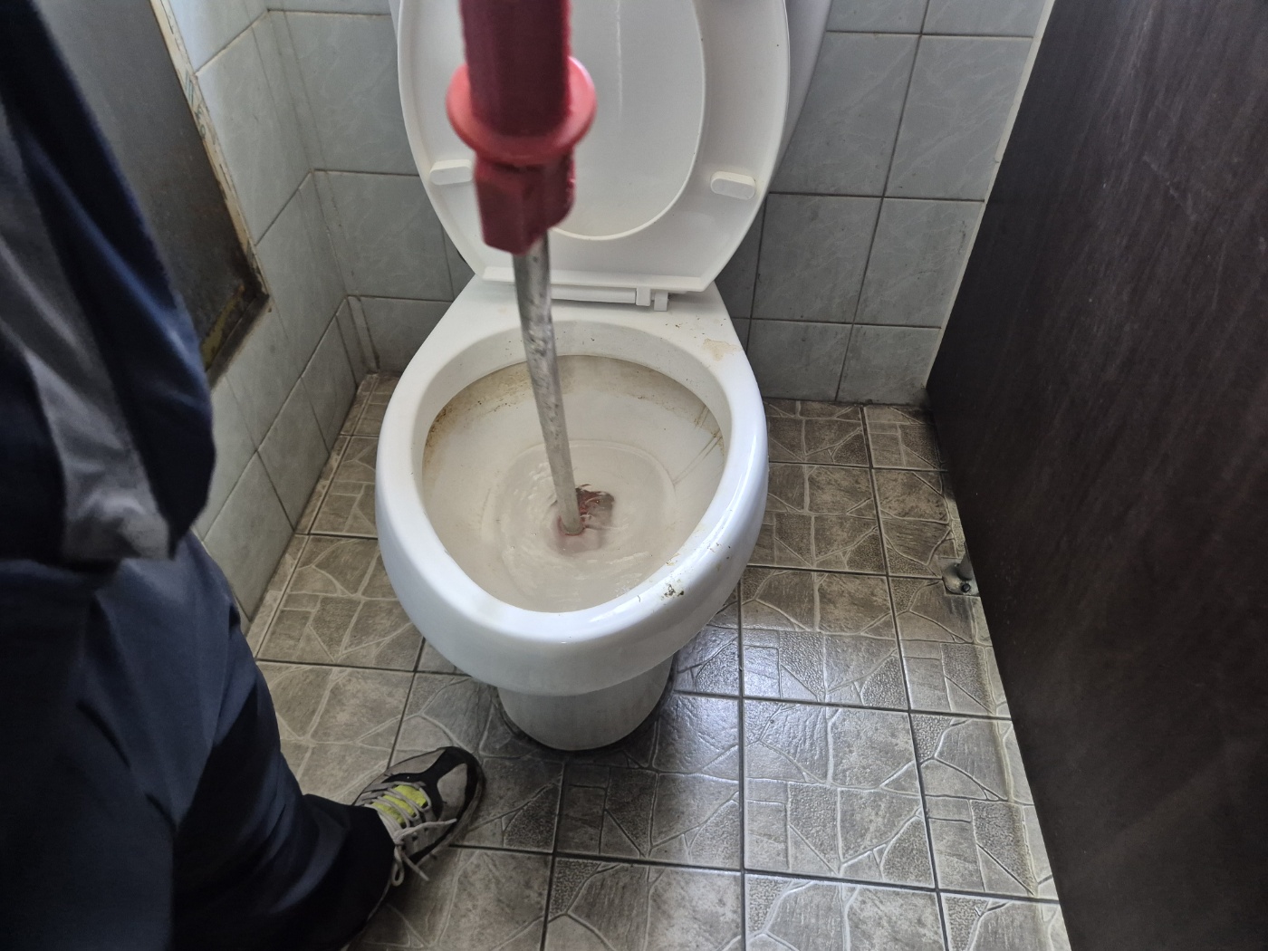 변기 안으로 와이어를 밀어 넣는 사진