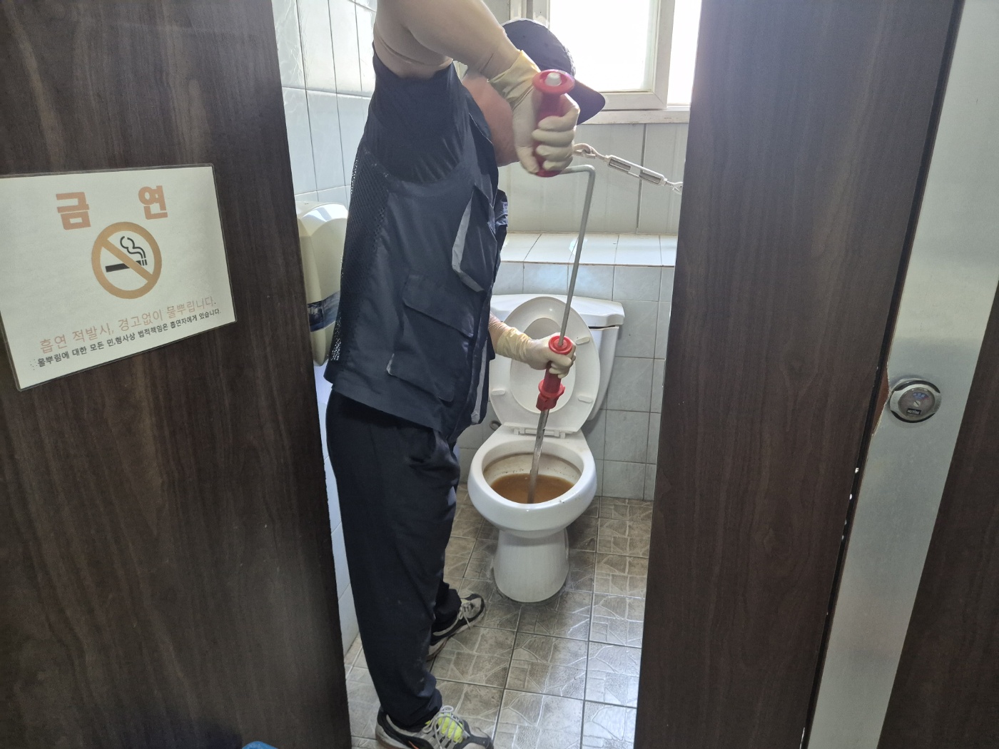 화장실 칸에서 전동 와이어 작업을 이어가는 사진