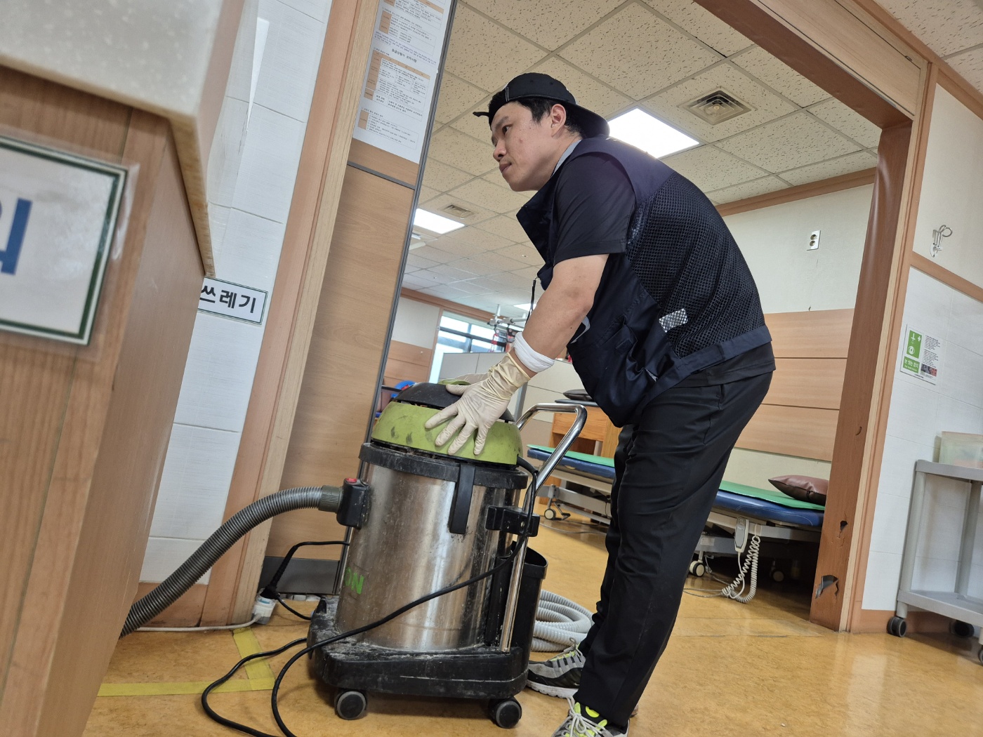 병원 복도에서 석션기를 옮기는 사진